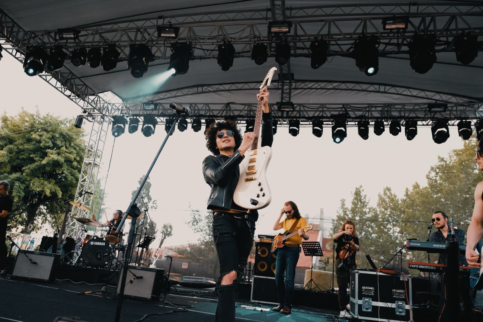 Batu Akdeniz raising his guitar on stage