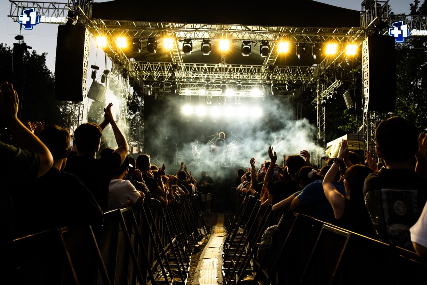 The stage under golden light and smoke, seen from the crowd